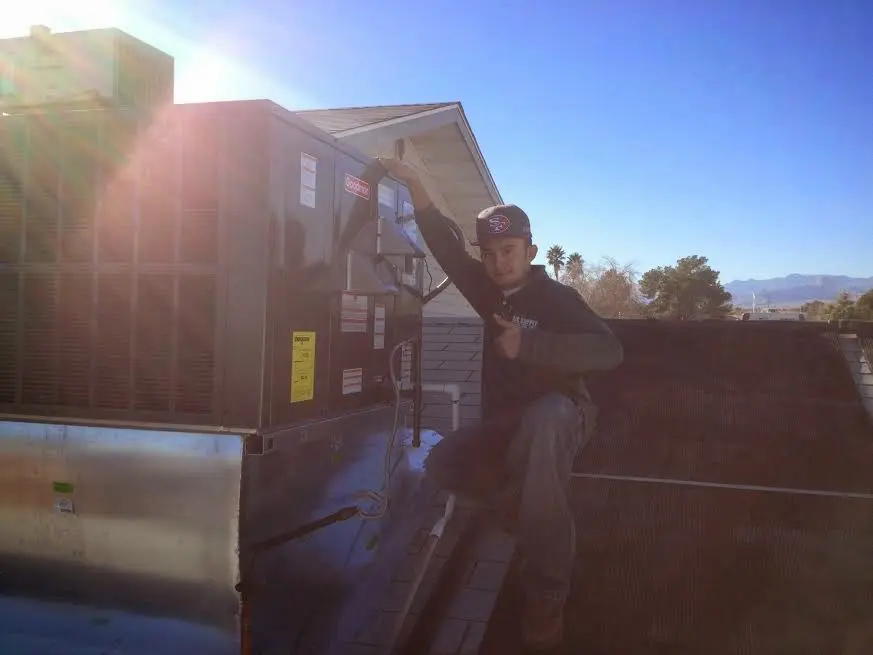HVAC technician performing AC Tune-Up on a rooftop unit in White Plains